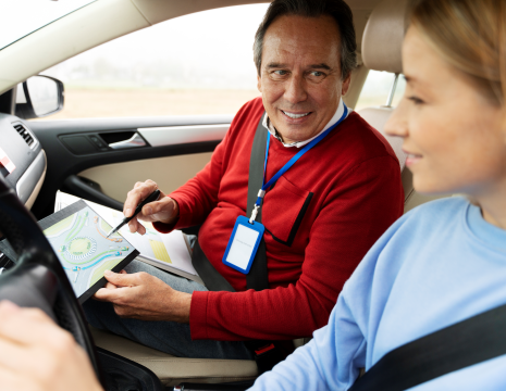 Instructor evaluating a student during a realistic driving mock test session.