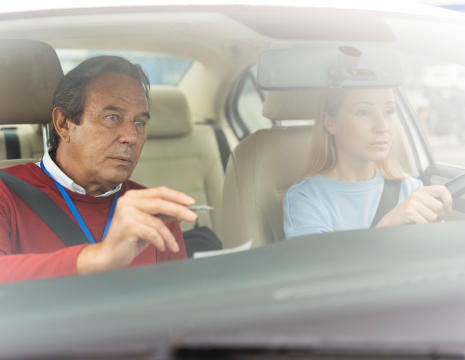 A young driver receiving a Pass Plus certificate after completing advanced training.